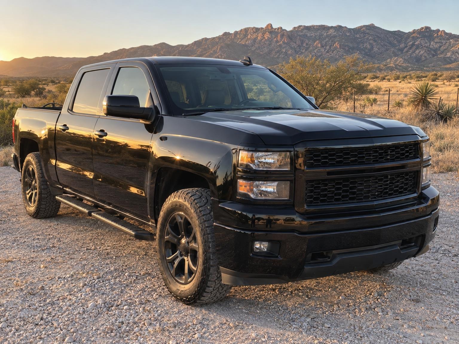 Black pickup truck with glossy paint after a detail, desert mountains behind